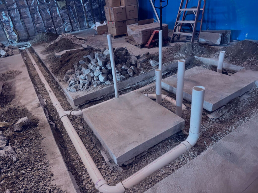 New plumbing system installation with PVC pipes in concrete foundation for residential or commercial property in the DMV area