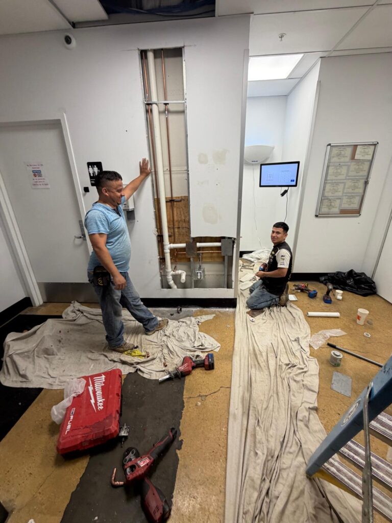 Plumbing team installing copper and PVC pipes for drinking fountain